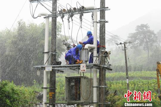 图为在长汀县南山镇抢修现场，抢修人员顶着暴雨安装新的变压器，确保居民用电可靠。　袁鸿梅 摄