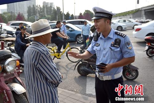 6月21日上午，北京交警敖翔正在处理交通违法行为。记者 金硕 摄