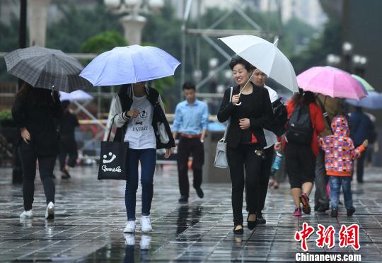 资料图：民众雨中出行。陈超 摄